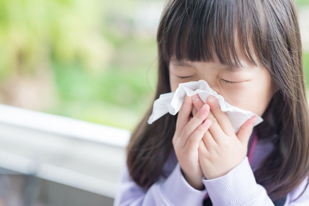 little girl blowing. her nose