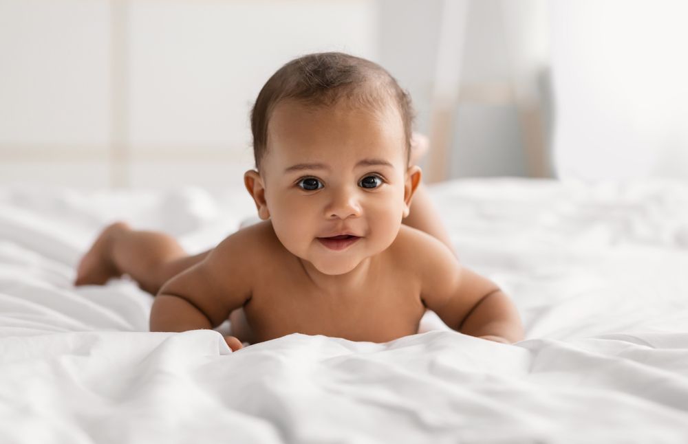 Baby laying on tummy on bed