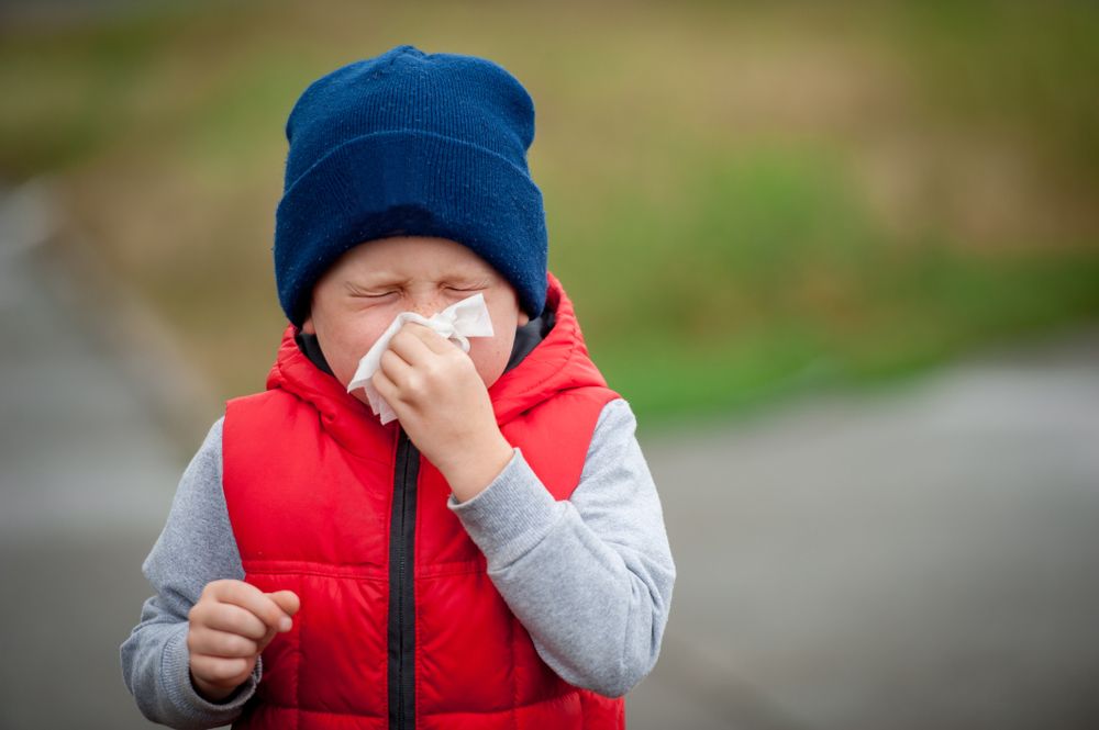 Kid blowing nose.