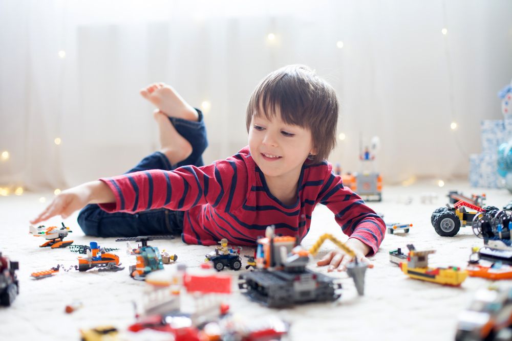 Kid playing with toys on the ground.