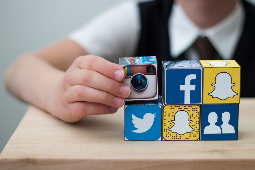 child with blocks of social media logos